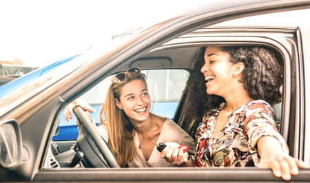 Young female best friends having fun at car roadtrip moment - Transportation concept and urban ordinary life with women girlfriends at happy travel vacation on the road - Bright azure filterの写真素材