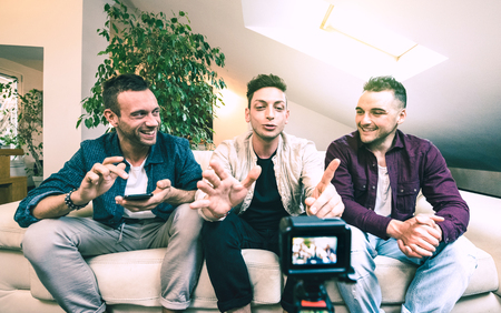 Young millennial friends sharing content on streaming platform through digital action webcam - Influencer marketing concept with millenial guys having fun vlogging live feeds on social media networksの写真素材