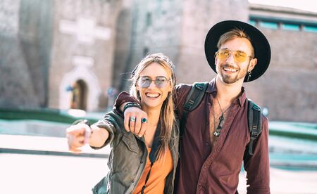 Happy boyfriend and girlfriend in love having genuine fun walking in city center - Wanderlust life style and travel vacation concept with tourist couple at old town tour on warm filter - Focus on guyの写真素材