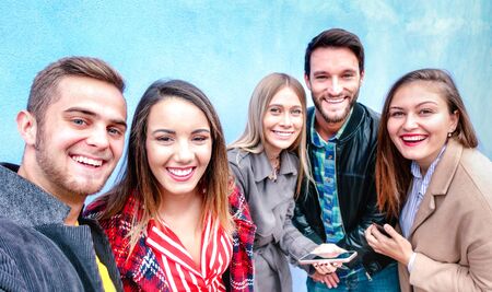 Best friends taking selfie wearing four seasonal clothes - Happy lifestyle concept with millenial...