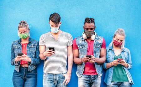 Multiracial friends with face masks using tracking app with mobile smart phones - Young millenial...