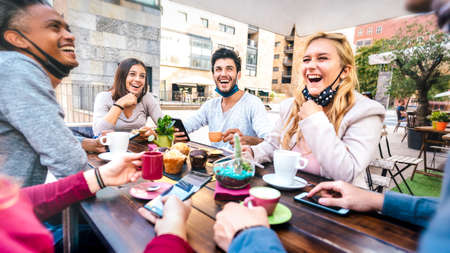 Friends having fun drinking cappuccino at coffee house - Young people laughing together at...