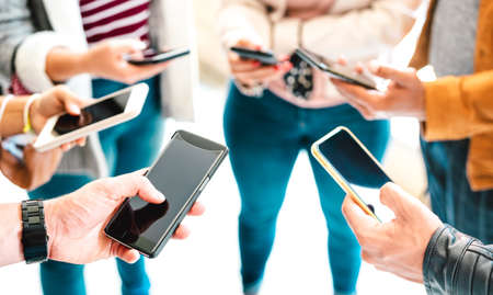 Friends group sharing content on mobile smart phone - Close up of people hands using tracking app with social media network - Technology concept with always connected millenials - Vivid bright filterの写真素材