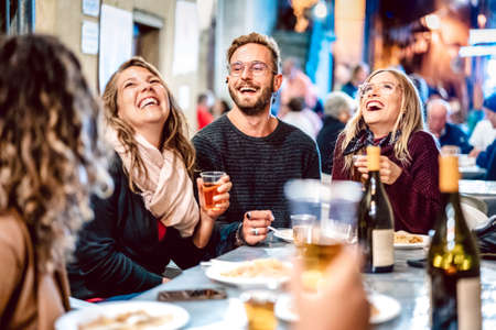 Happy friends having fun drinking white wine at street food festival - Young people eating local plate at restaurant reopening together - Travel and dinning lifestyle concept on azur light neon filterの写真素材