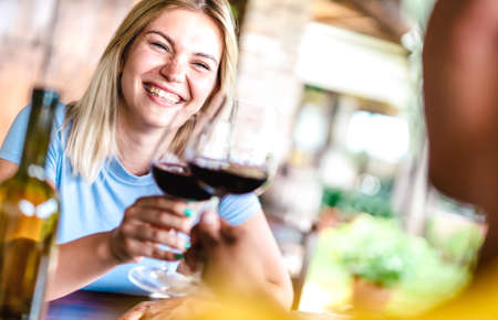 Tilted crop of happy couple toasting red wine at countryside restaurant - Food and beverage life style concept with boyfriend and girlfriend on having fun drinking togetherの写真素材