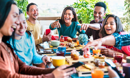 Friends group talking at coffee bar rooftop - Diverse people having fun together at outside cafeteria on brunch time - Life style concept with happy guys and girls at cafe venue - Bright vivid filterの写真素材