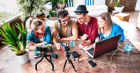 Milenial people sharing content on streaming platform with digital web camera - Modern lifestyle concept with smart millenial guys and girls having fun vlogging live feeds on social media networksの写真素材
