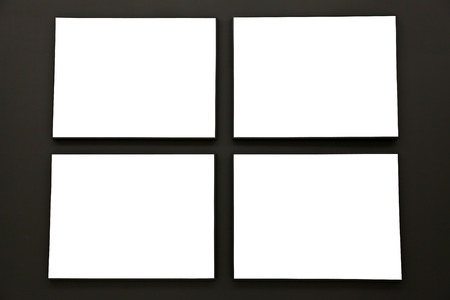 Blank painting frames on black wallの写真素材