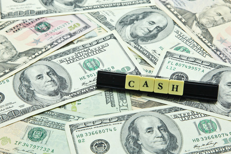Word cash on pile of US dollar banknotesの写真素材