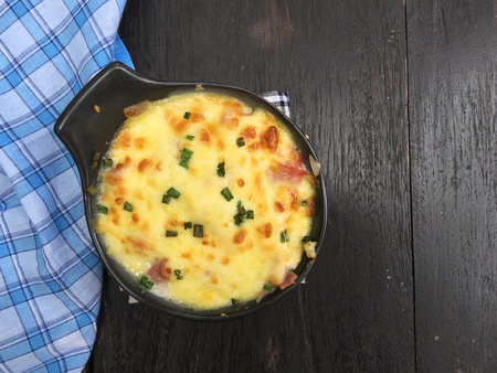 Baked potato with cheese and bacon garnished with parsley on wood table. top view.の写真素材