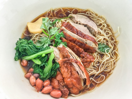 Roasted duck noodle with vegetable, ginger and peanut in restaurant. top view.の写真素材