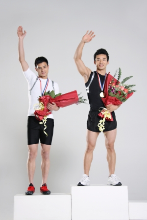Young male athletes holding trophy and flowers
の写真素材