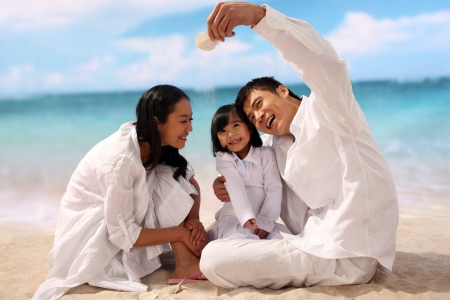 Family of three playing at beachの写真素材
