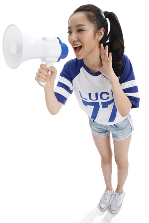 The young woman holding a microphone shoutedの写真素材