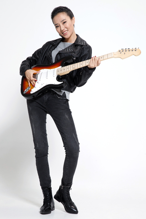 Young woman playing guitarの写真素材