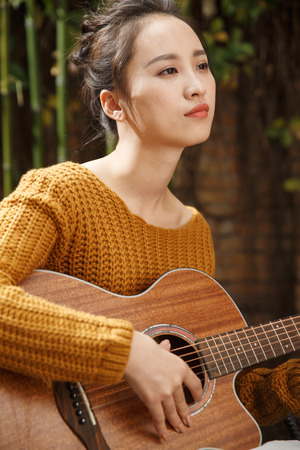 Young woman playing guitarの写真素材
