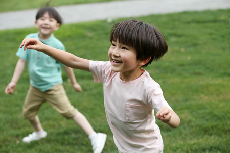 Children are playing on the grassの写真素材
