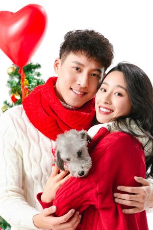 Young couple with a dog celebrating Christmasの写真素材