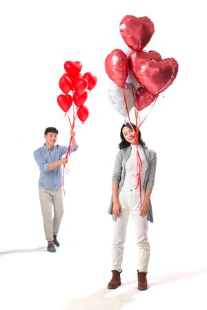 Romantic couple with heart-shaped balloonsの写真素材