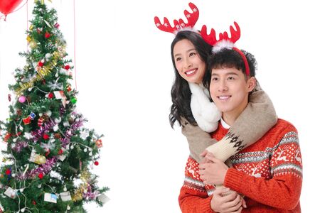 Happy young couple embracing while celebrating Christmasの写真素材