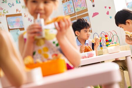 Kindergarten children eating breakfastの写真素材