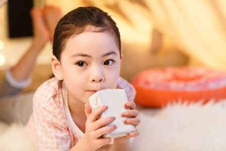 Cute little girl drinking milkの写真素材