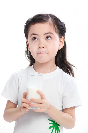 Cute little girl drinks milkの写真素材