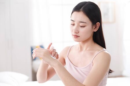 Young women applying body lotionの写真素材
