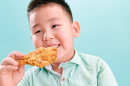 Lovely boy eating Fried chickenの写真素材