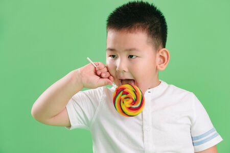 Lovely boy holding a lollipopの写真素材