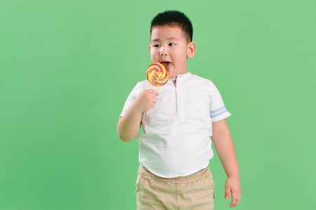Lovely boy holding a lollipopの写真素材