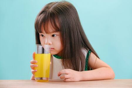 Lovely little girl drink orange juiceの写真素材