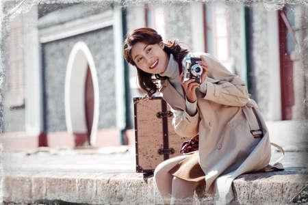 The young woman holding a camera to travel