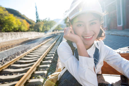 Young woman sitting on the railway platformの写真素材