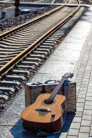 Guitar and suitcases next to the tracksの写真素材