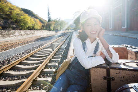 Young woman sitting on the railway platform