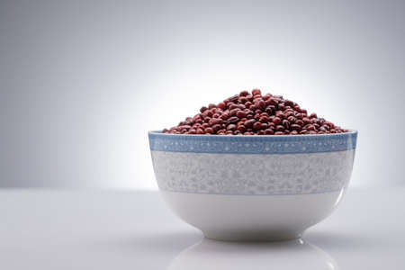 a bowl of red bean under the background of greyの写真素材