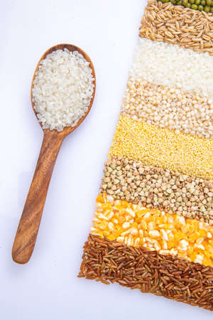 Filled with wooden spoon and grain of riceの写真素材