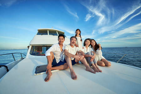 Happy family aboard a yacht out to seaの写真素材
