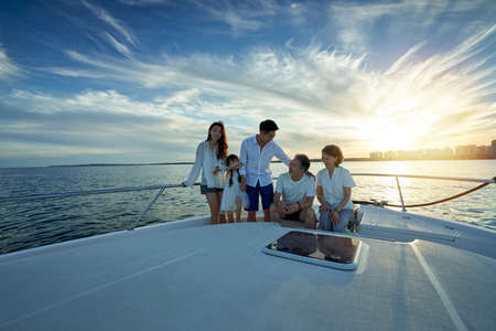 Happy family aboard a yacht out to seaの写真素材
