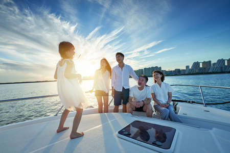 Happy family aboard a yacht out to seaの写真素材
