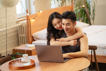Happy asian couple using laptop computer in bedroom at home. Lifestyle concept.の写真素材