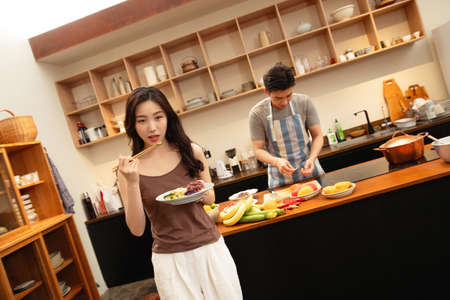 Young couple cooking together in the kitchen at home. Healthy food and lifestyle concept.の写真素材