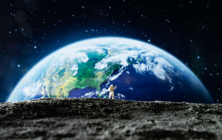 Miniature people : Astronaut standing on the edge of the earth. Concept of Earth Day.