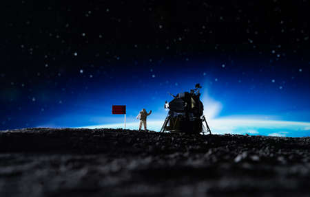 Silhouette of a man standing in front of a red flag on the background of a starry night sky. The concept of achieving goals.の写真素材