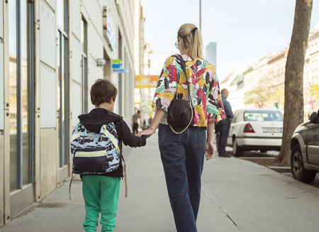 Cute little boy going to school with his mother