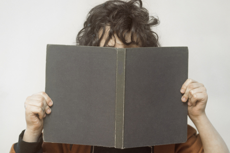 a boy with a book in his handsの写真素材