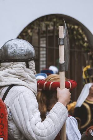 Actors wearing medieval costumes, one of them standing with sword during festival