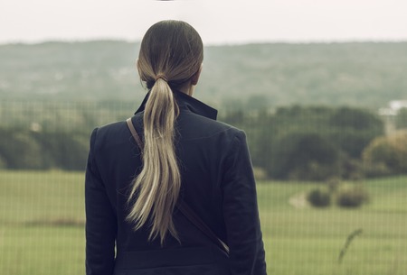 Female in the green field admires surrounding beautyの写真素材