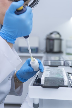 Scientist with dropper working at the laboratory